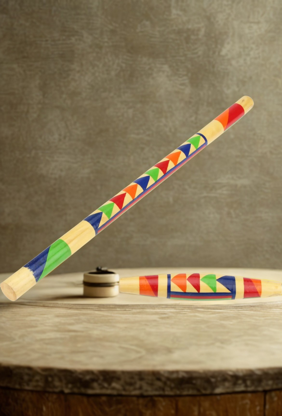 Colorful stick and puck with geometric pattern on a wooden surface and brown background
