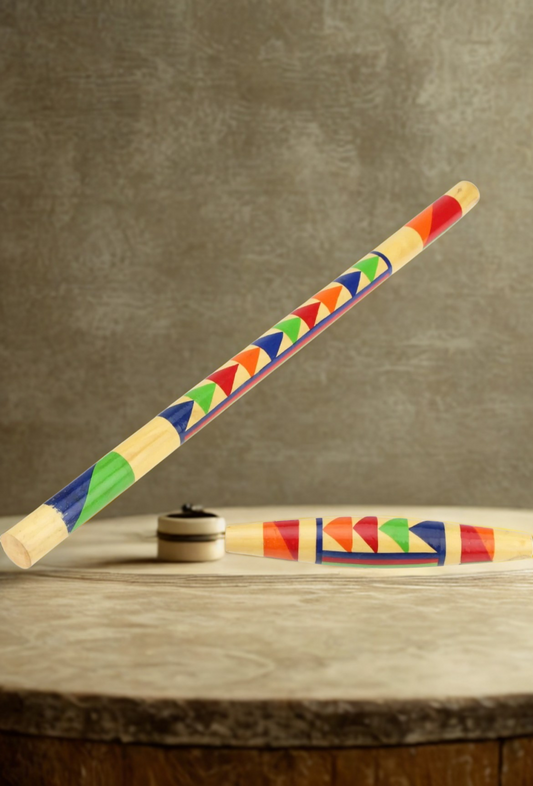 Colorful stick and puck with geometric pattern on a wooden surface and brown background