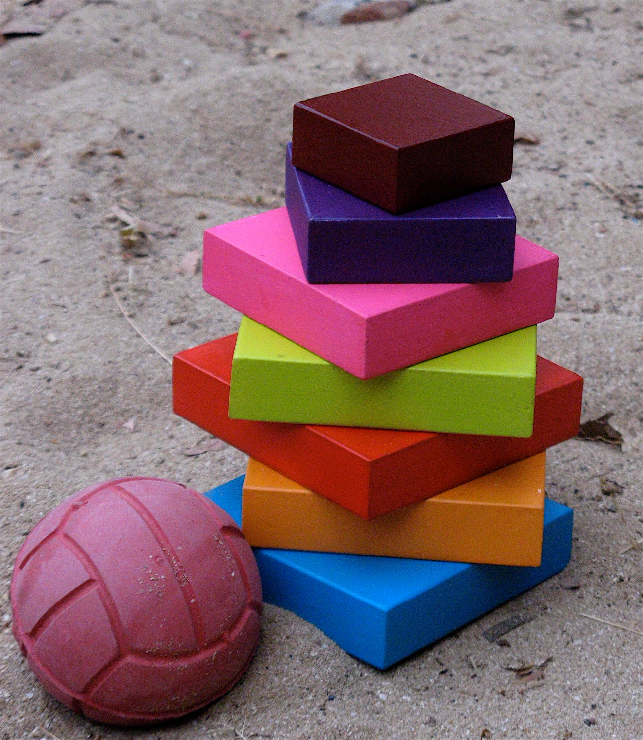 Stack of colorful wooden blocks on a sandy terrain