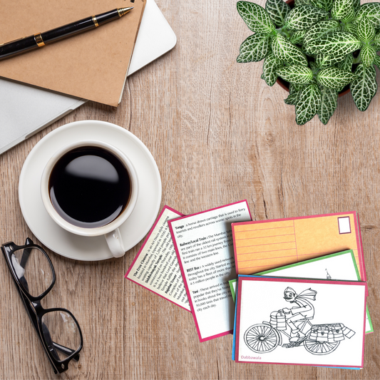 Desk with coffee, glasses, and postcards on a wooden surface