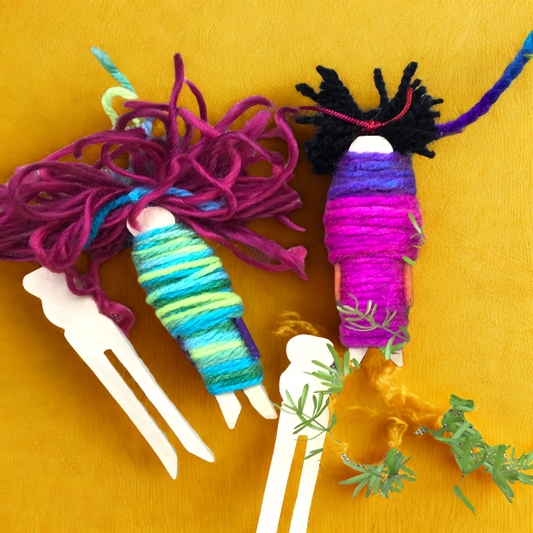 Colorful yarn-wrapped craft project creating dolls